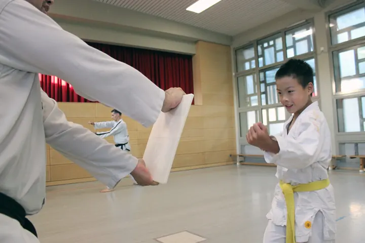 Kind beim Taekwon-Do-Training mit einem Trainer