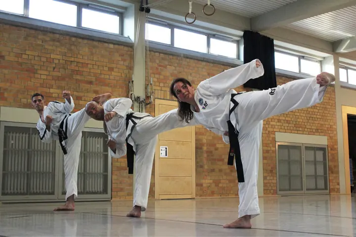 Erwachsene trainieren gemeinsam eine Taekwon-Do-Technik
